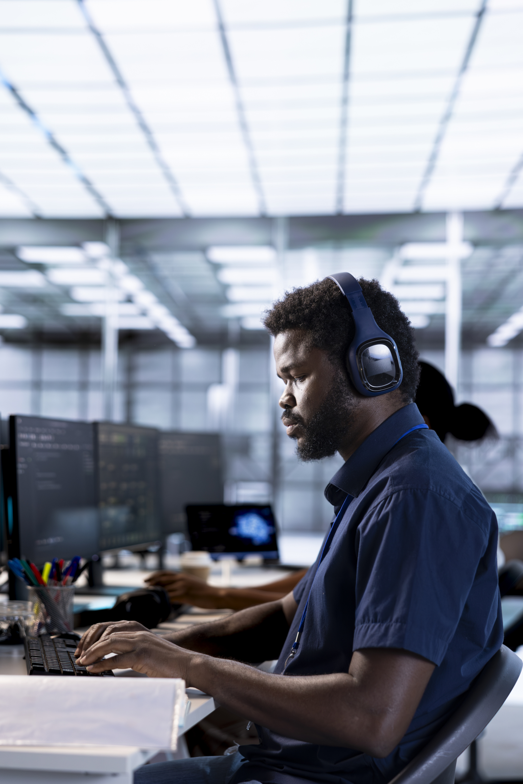 System administrator reconfiguring server farm to optimize it for data processing requirements of customers. IT professional working to ensure data center gear operates efficiently