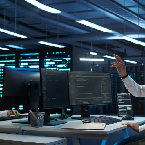 Data center admin responsible for installation of networking systems wearing high tech VR headset. IT worker doing maintenance on server farm gear using virtual reality technology, camera B