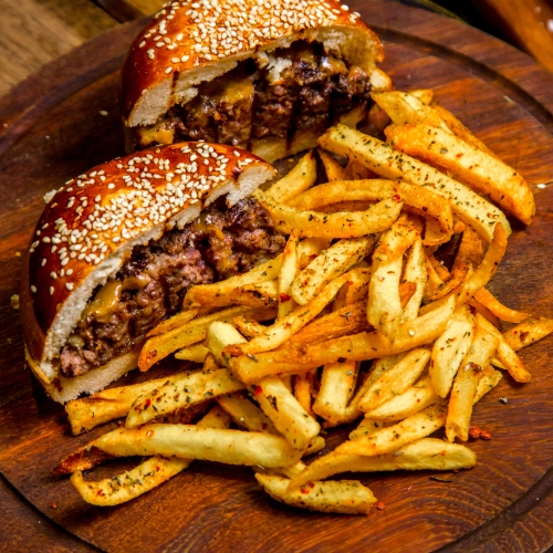meat burger on wooden board french fries side view